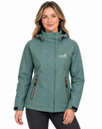 A woman modelling a sage green hooded outdoor jacket with zippered pockets and a white 'wild life' logo on the chest, set against a plain white background.
