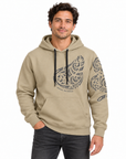 A man wearing a beige pullover hoodie with black graphic prints on the chest and sleeve, paired with dark gray jeans, against a plain white background.