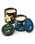 Three Wild Kiwi New Zealand scented travel candles in black metal tins with colourful lids, displayed on a light beige background. The candles include Manuka Honey, Pohutuaka & Sea Salt, and Wild Kiwi New Zealand scented candles.