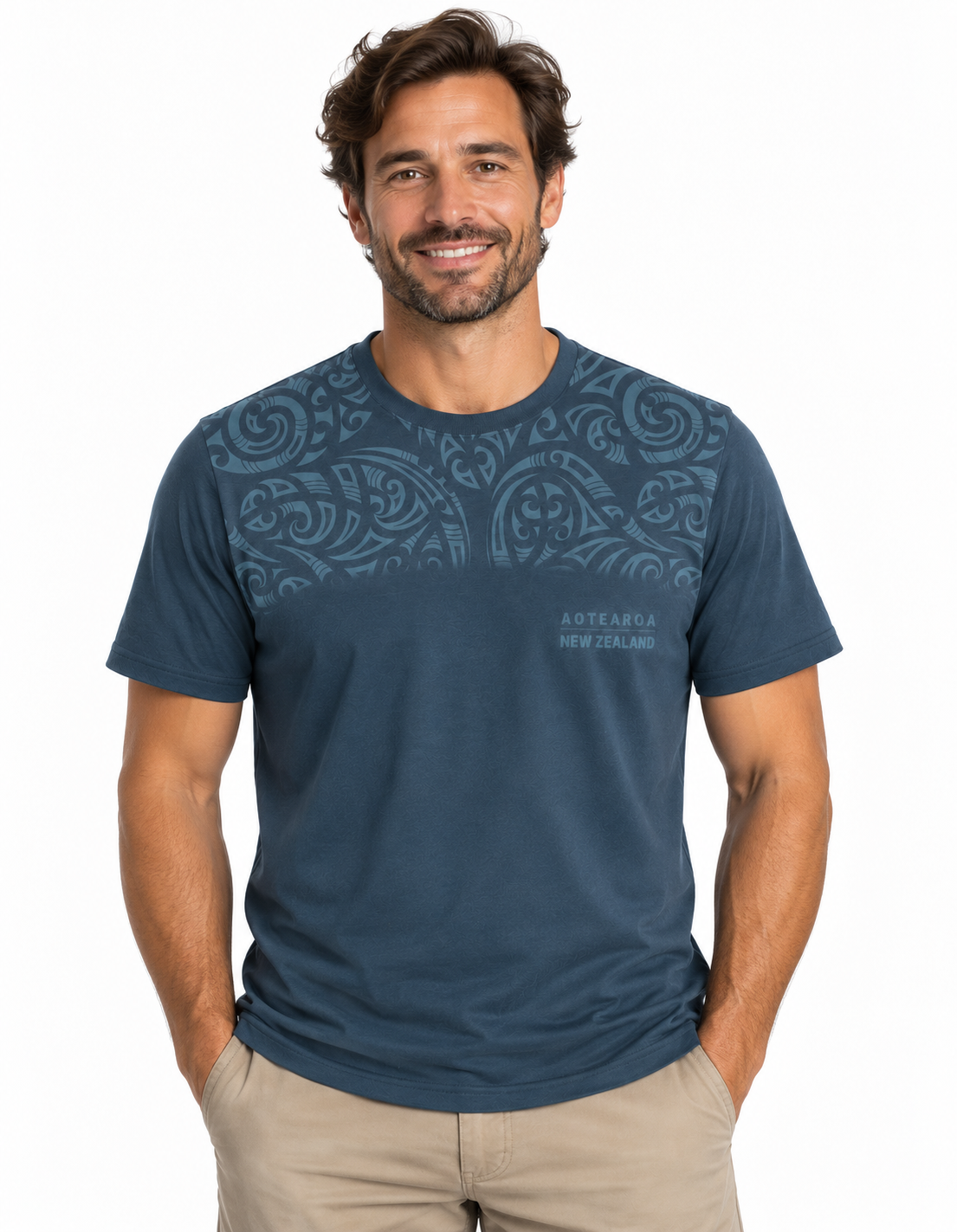 A man wearing a dark blue short-sleeve t-shirt with a subtle tribal pattern across the chest and 'AUSTRALIA NEW ZEALAND' text on the lower right chest, paired with khaki pants, against a plain white background.