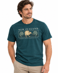 A man wearing a dark teal heathered t-shirt with a beige graphic of a kiwi bird and the text 'NEW ZEALAND' and 'AOTAROA - LAND OF THE LONG WHITE EAGLE'.