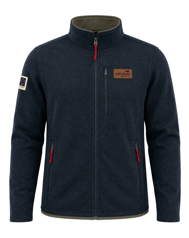 A dark navy blue fleece jacket with a stand-up collar, front zipper, zippered hand pockets, and red zipper pulls, shown on a plain white background. A brown brand patch is visible on the left chest, and a small sleeve patch is visible on the right sleeve.