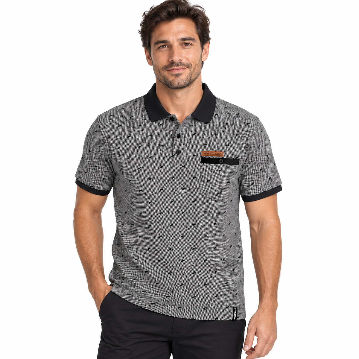 A man wearing a gray short-sleeve polo shirt with a black collar, black trim on the cuffs and pocket, and a small orange logo on the chest pocket, paired with black pants against a plain white background.