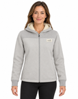 A woman wearing a light gray zip-up hoodie with a cream sherpa-lined hood and a small 'The North Face' logo patch on the left chest, set against a plain white background.