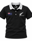 A black short-sleeve polo shirt with a white collar, featuring a New Zealand flag patch on the left chest and a white New Zealand fern logo with 'NEW ZEALAND' text on the right chest. The inner collar shows the brand 'wild kiwi'.