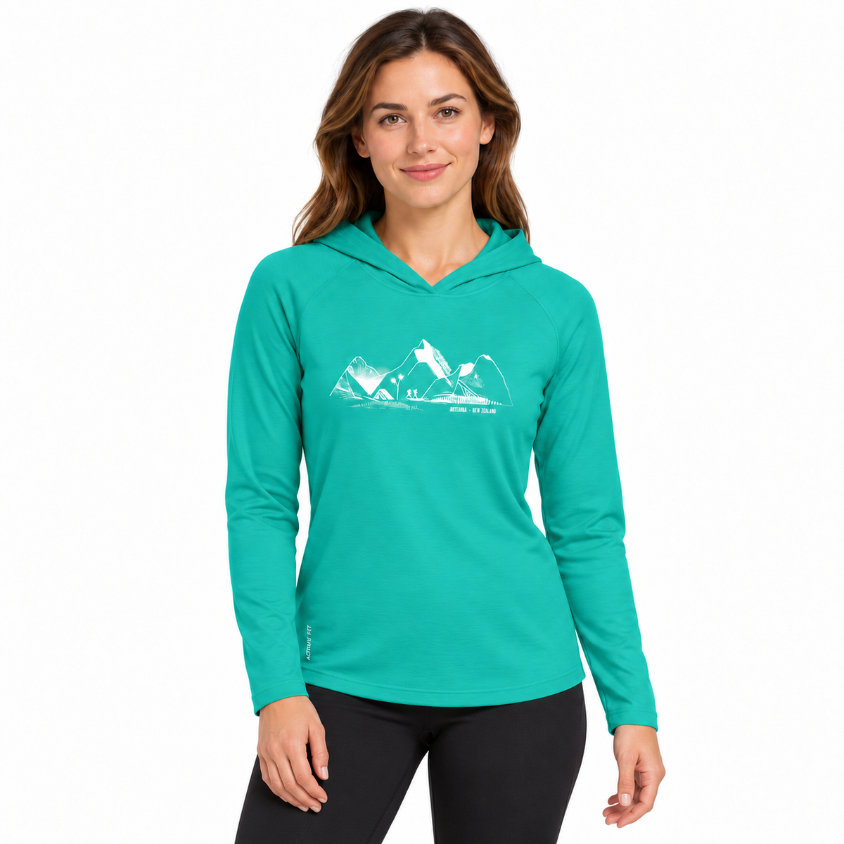A woman modeling a teal long-sleeve hooded athletic shirt with a white mountain graphic and the words 'THE PEAK' on the chest, paired with black leggings, against a plain white background.