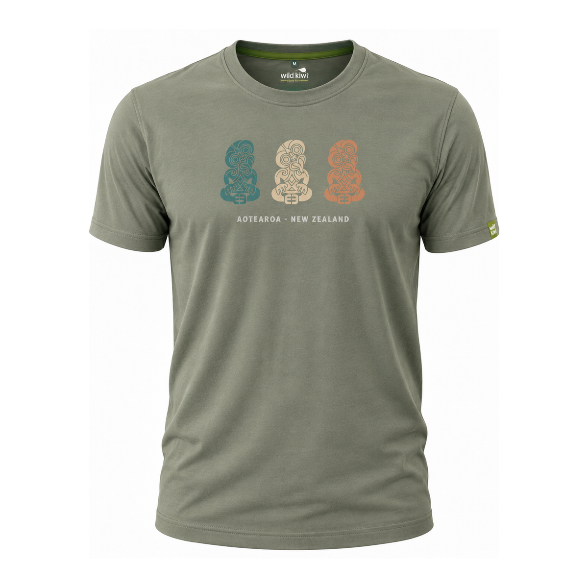 An olive green short-sleeve t-shirt with a graphic of three New Zealand Moko statues in teal, beige, and orange, with the text 'AOTEAROA - NEW ZEALAND' printed below. The brand 'Well-Tuned' is visible on the inner neck label and as a small yellow logo on the sleeve.