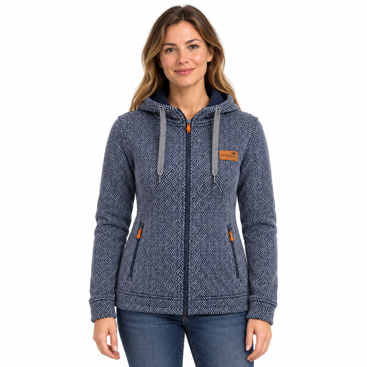 A woman wearing a navy blue and gray patterned zip-up hoodie with orange accents, paired with blue jeans, against a plain white background.