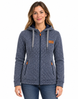 A woman wearing a navy blue and gray patterned zip-up hoodie with orange accents, paired with blue jeans, against a plain white background.